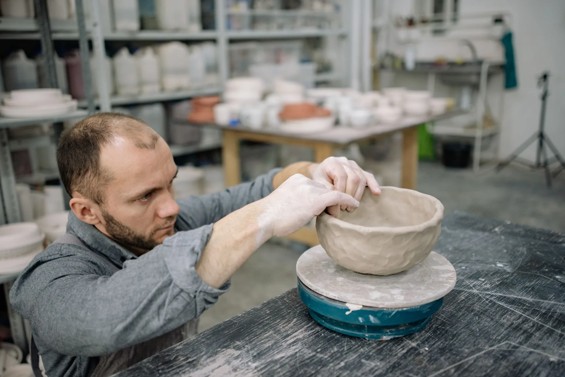 A ceramic artist shaping clay in a workshop
